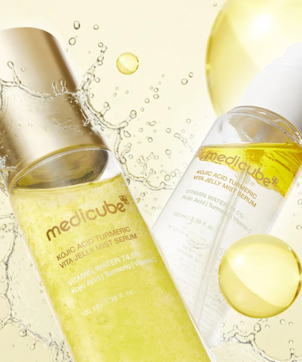 Ultra-fine, non-sticky micro-mist spray pattern of Medicube Kojic Acid Turmeric Vita Jelly Serum melting onto a glowing complexion at Atelier De Glow UAE.