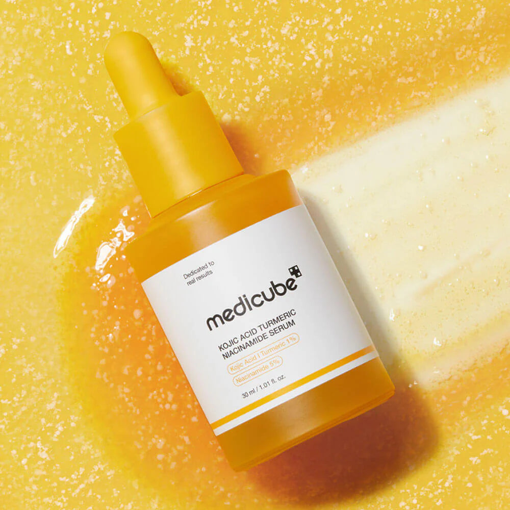 Smooth, weightless, and naturally gold-tinted fluid texture of Medicube Kojic Acid Turmeric Serum absorbing quickly into a texturized canvas at Atelier De Glow UAE.