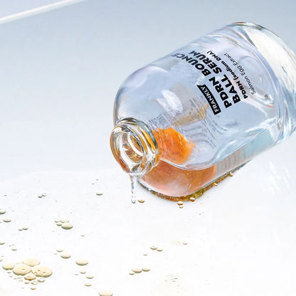 Innovative dual-layer texture of FRANKLY PDRN Serum showing the orange oil capsules blending into a clear watery essence at Atelier De Glow UAE.