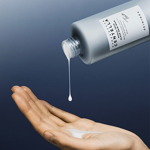 Silk-like, featherlight, and non-sticky white fluid milk texture of SKIN1004 Hyalu-Teca Glass Skin Milk absorbing instantly into a face at Atelier De Glow UAE.