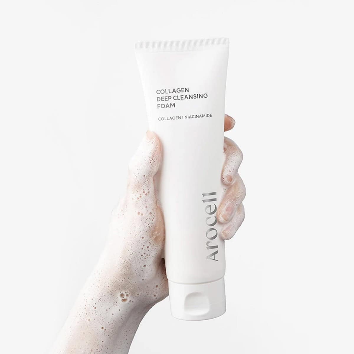 Rich, whipped, and cushion-soft dense white foam texture of Arocell Collagen Deep Cleansing Foam purifying a damp face at Atelier De Glow UAE.