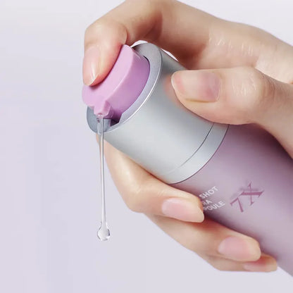 Rich, milky, and ultra-smooth fluid texture of Arocell Super Shot Coltra Ampoule 7X being dispensed from a dropper onto a clear face at Atelier De Glow UAE.