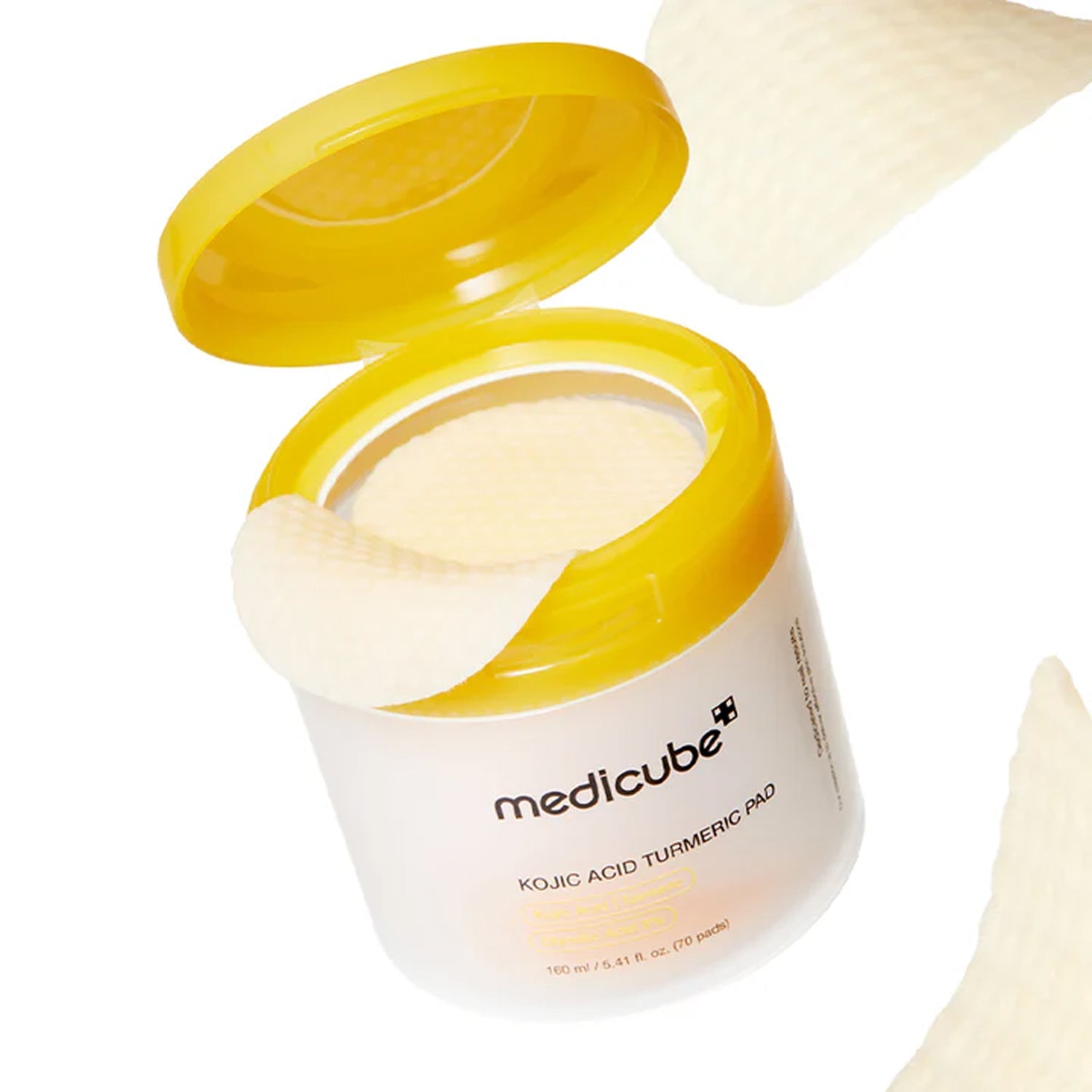 Smooth, naturally gold-tinted brightening essence soaking into the dual-embossed cotton texture of Medicube Kojic Acid Turmeric Pads at Atelier De Glow UAE.