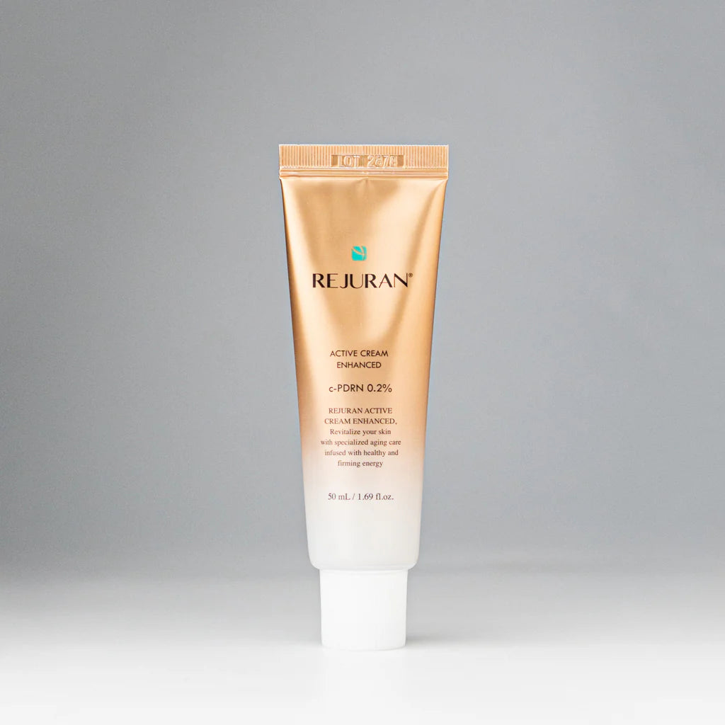 Rich, whipped, and cushion-soft white cream texture of REJURAN Active Cream Enhanced melting effortlessly into a face at Atelier De Glow UAE.